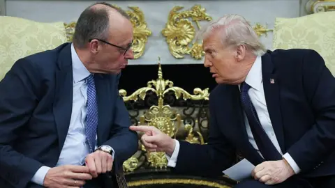 Ảnh: Getty Images. Ông Trump và ông Merz nói chuyện trong Phòng Bầu dục. Họ ngồi và nghiêng người về phía nhau. Ông Trump chỉ tay vào ông Merz.